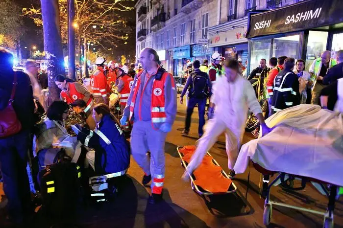 People rest on a bench after being evacuated from the Bataclan theater after a shooting in Paris, Saturday, Nov. 14, 2015. A series of attacks targeting young concert-goers, soccer fans and Parisians enjoying a Friday night out at popular nightspots killed over 100 people in the deadliest violence to strike France since World War II.  (ANSA/AP Photo/Thibault Camus)