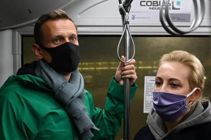 Russian opposition leader Alexei Navalny and his wife Yulia ride on a bus from a plane to a terminal of Moscow\\'s Sheremetyevo airport on January 17, 2021. - Chief Kremlin critic Alexei Navalny returns to Russia from Germany on January 17, facing imminent arrest after authorities warned they would detain him. The 44-year-old opposition leader is flying back to Moscow after spending several months in Germany recovering from a poisoning attack that he said was carried out on the orders of President Vladimir Putin. (Photo by Kirill KUDRYAVTSEV / AFP)
