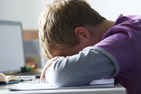 Tired Boy Studying In Bedroom