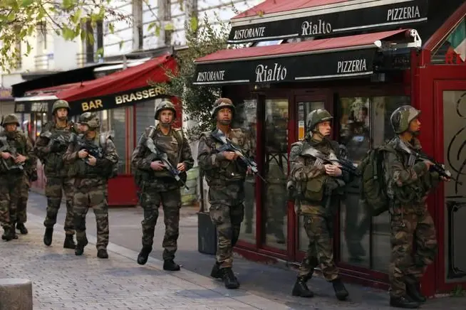 Soldiers operate in St. Denis, a northern suburb of Paris, Wednesday, Nov. 18, 2015. Authorities in the Paris suburb of St. Denis are telling residents to stay inside during a large police operation near France\\'s national stadium that two officials say is linked to last week\\'s deadly attacks. (ANSA/AP Photo/Francois Mori)