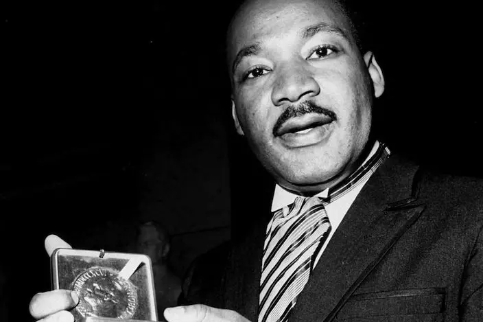 Dr. Martin Luther King, Jr. displays his 1964 Nobel Peace Prize medal in Oslo, Norway, December 10, 1964.  The 35-year-old Dr. King was honored for promoting the principle of non-violence in the civil rights movement.  (AP Photo)