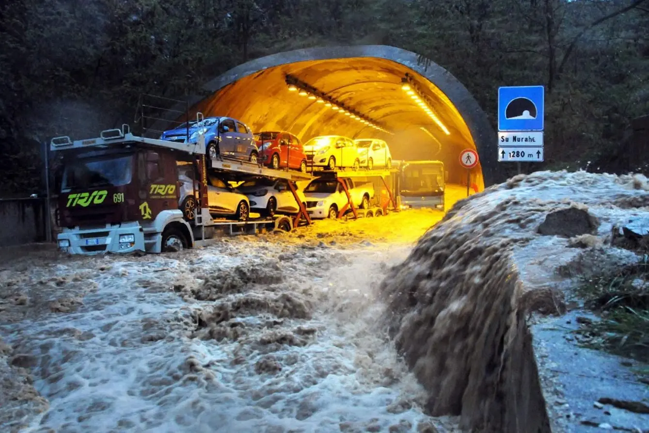 In this photo taken on Monday, Nov. 18, 2013 a truck and a bus are stranded by flood waters in a tunnel near Olbia, Italy. The Mediterranean island of Sardinia, prized by the jet-set for its white sand beaches and crystal-clear seas, was a flood-ravaged mud bath Tuesday after a freak torrential rainstorm killed at least 17 people, downed bridges and swept away cars. Olbia Mayor Gianni Giovannelli said the city had been destroyed by the &quot;apocalyptic&quot; storm, with bridges felled and water levels reaching 3 meters (10 feet) in some places. He described the ferocity of the storm\\'s rains as a &quot;water bomb.&quot; (AP Photo/Massimo Locci)