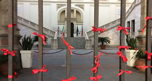 Nastri rossi contro la violenza sulle donne all'ingresso del Palazzo Civico