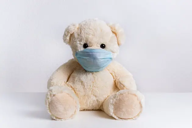 Cute teddy bear with protective medical mask on his face. Concept of of illness, hygiene and virus protection for child patient during epidemic. Fluffy toy on white background