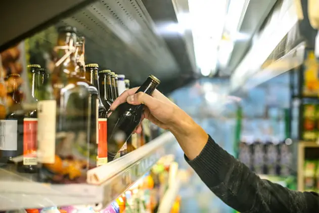 Unrecognizable man buying beer in a supermarket store.