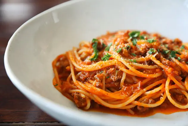 spaghetti Bolognese with minced beef and tomato sauce garnished with parmesan cheese and basil , Italian food