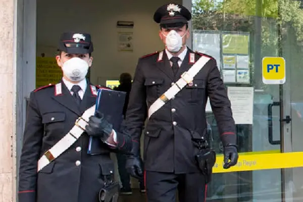 Due Carabinieri davanti ad un ufficio postale. ANSA/MAURIZIO BRAMBATTI