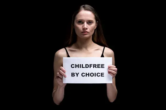 Woman showing childfree by choice sign, voluntary refusal from children, freedom