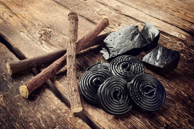 Production steps of licorice, roots, pure blocks and candy on wooden table