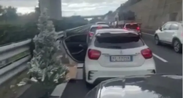 Si stanca della coda autostradale e addobba l'albero di natale durante l'attesa