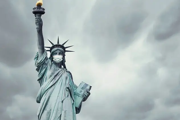Stock photo of the New York\\'s Statue of Liberty with a mask on its face caused by the coronavirus covid-19 and copy space on the right