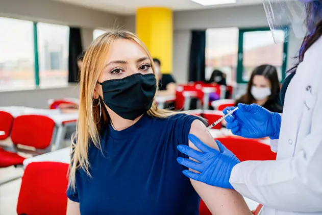 Nurse gives students a vaccination in school during coronavirus pandemic