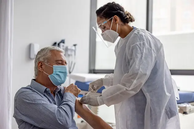 Adult Latin American man getting the COVID-19 vaccine at the hospital during the pandemic