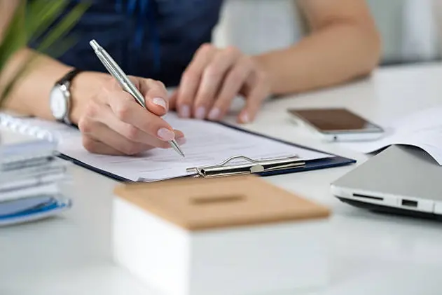 Close-up of female hands. Woman writing something  sitting at her office