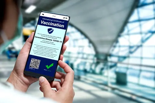 Traveler holds vaccine passport certificate to show COVID 19 vaccination status . The digital health certificate is required for international travel during coronavirus pandemic .