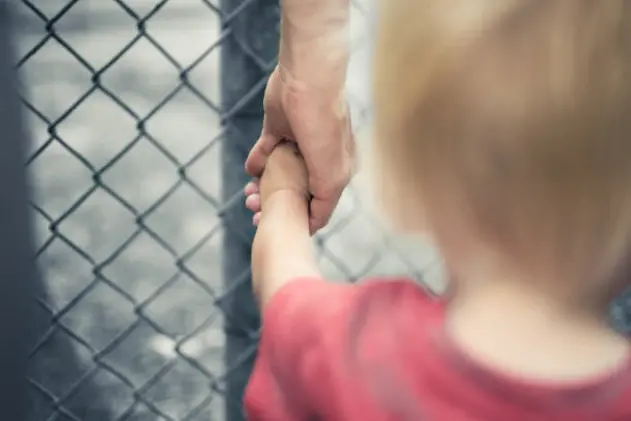 Child holding woman\\'s hand.