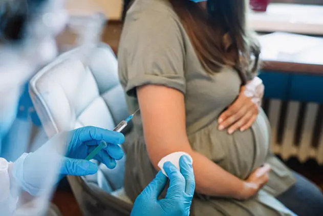 Pregnant woman getting vaccine at home. COVID-19 vaccination concept.