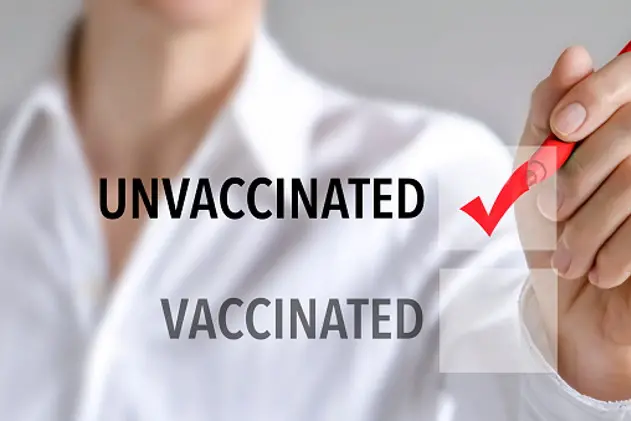 Woman making a check mark to be unvaccinated on the white visual board.