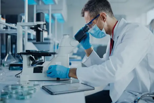 Medical Development Laboratory: Scientist Wearing Face Mask Looking Under Microscope and Using Digital Tablet. Specialists Working on Medicine, Biotechnology Research in Advanced Pharma Lab