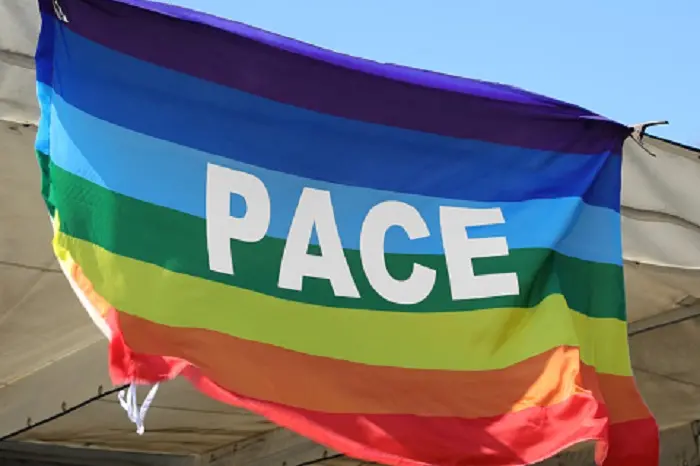 multicolored flag with the big Italian word PACE which means peace and symbolizes non-violence and no war