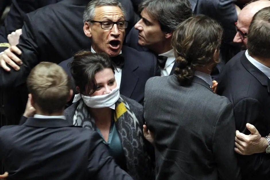 Loredana Lupo (con il bavaglio bianco) durante la bagarre alla Camera subito dopo il voto finale al dl Imu-Bankitalia, Roma, 29 Gennaio 2014. ANSA/ GIUSEPPE LAMI 