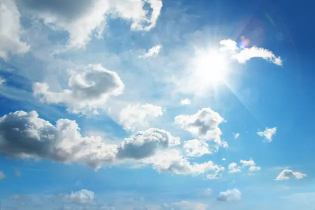 cloudscape image of shinning sun over blue sky and clouds