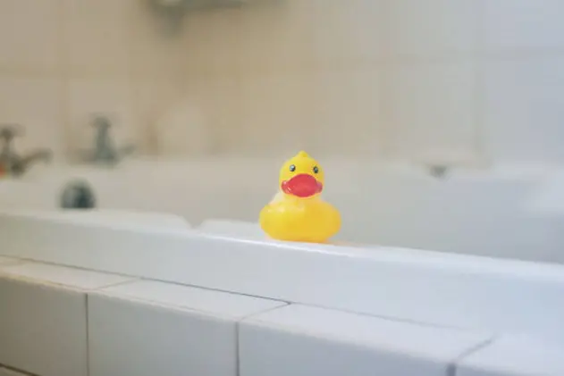 Shot of a rubber duck sitting on a bathtub at home