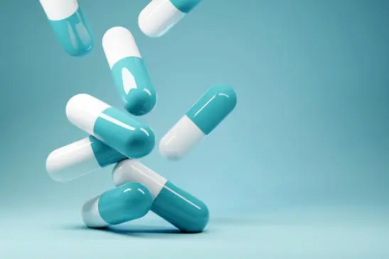 A group of antibiotic pill capsules fallling. Healthcare and medical 3D illustration background.