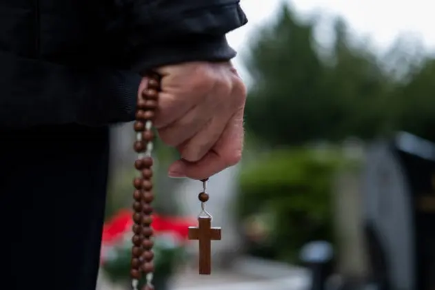 Man with crucifix on cemetery