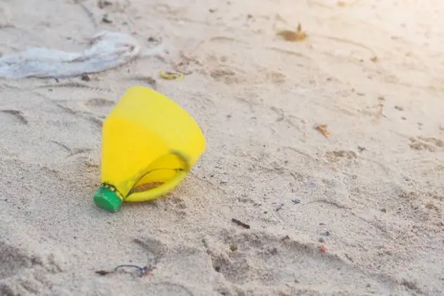 Yellow Plastic bottle on Beach Pollution Environment