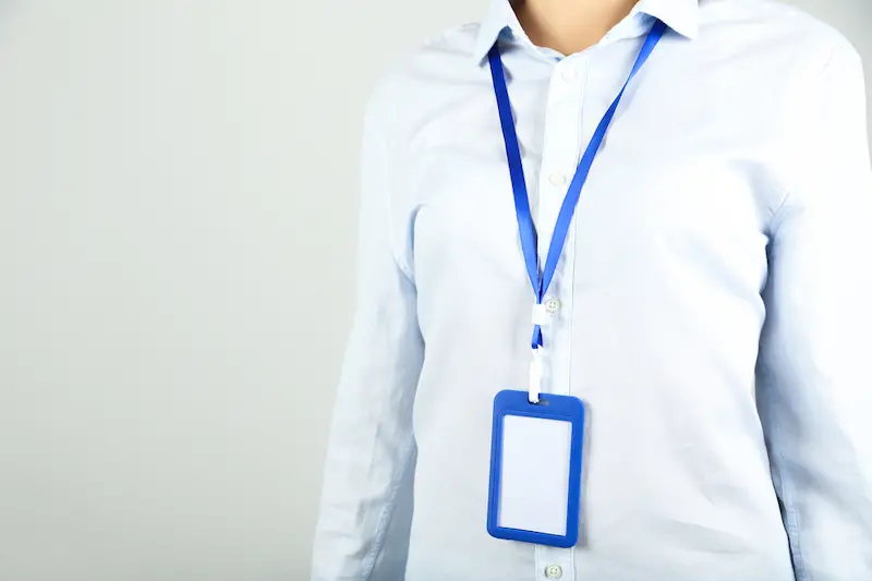 Businesswoman with blank bagde on grey background