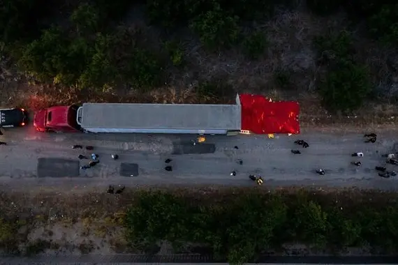 SAN ANTONIO, TX - JUNE 27: In this aerial view, members of law enforcement investigate a tractor trailer on June 27, 2022 in San Antonio, Texas. According to reports, at least 46 people, who are believed migrant workers from Mexico, were found dead in an abandoned tractor trailer. Over a dozen victims were found alive, suffering from heat stroke and taken to local hospitals.   Jordan Vonderhaar/Getty Images/AFP\\n== FOR NEWSPAPERS, INTERNET, TELCOS & TELEVISION USE ONLY ==