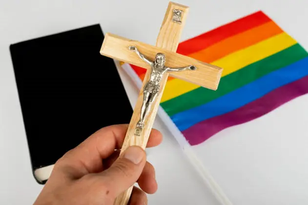 Picture of a bible, cross and a rainbow flag