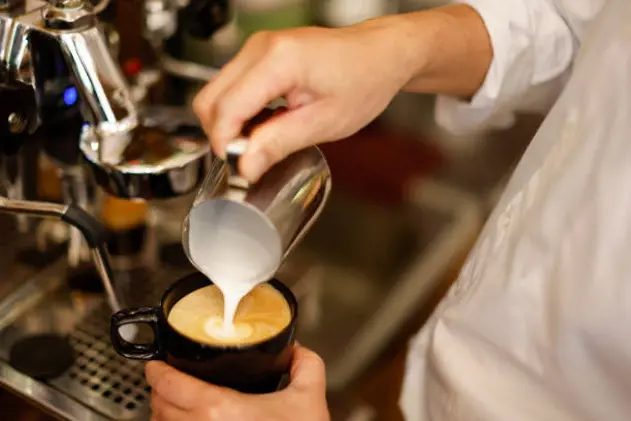 Barista hand making cappuccino Coffee with espresso machine in cafe