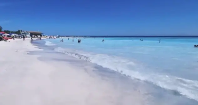 Sabbia bianca e mare azzurro fluo: sembra un paradiso ma cosa si nasconde dietro questi colori?