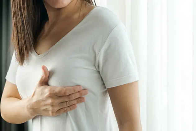 Woman hand checking lumps on her breast for signs of breast cancer. Women healthcare concept.