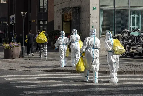 Workers wearing personal protective equipmet (PPE) carry bags of test kits near a neighborhood placed under lockdown due to Covid-19 in Shanghai, China, on Wednesday, March 16, 2022. Shanghai ruled out imposing a broad lockdown for now, while urging workers in its main financial and business district to work from home as officials try to rein in a swelling Covid-19 outbreak in one of China\\u2019s biggest and most important cities.\\u00A0Photographer: Qilai Shen/Bloomberg