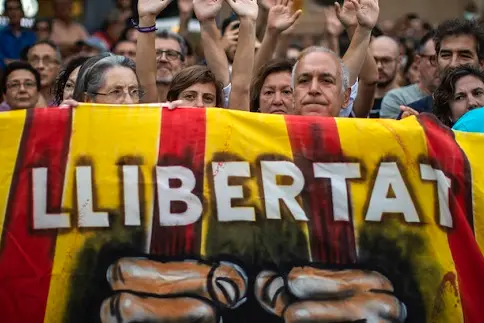 Pro independence demonstrators hold a banner reading in Catalan \"Freedom\" during a protest condemning the arrest of 9 Catalan activists by Spanish police on Monday, Sept. 23, 2019 in Sabadell, near Barcelona, Spain. Spanish prosecutors called for rebellion and terrorism charges to be leveled against nine activists linked to pro-Catalan independence groups who were arrested Monday on suspicion they may have been preparing to commit violent acts, possibly with explosives. (AP Photo/Emilio Morenatti)