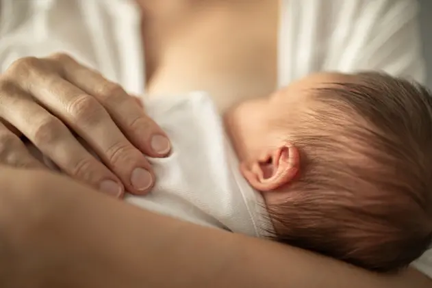 Mother breastfeeding her little baby girl. Breastfeeding and family concept.