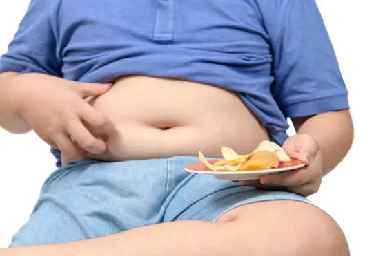 Obese fat boy holding potato chips isolated on white background, unhealthy food or junk food concept