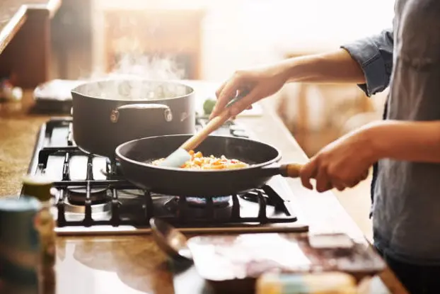 Cropped shot of a young woman preparing a meal at home