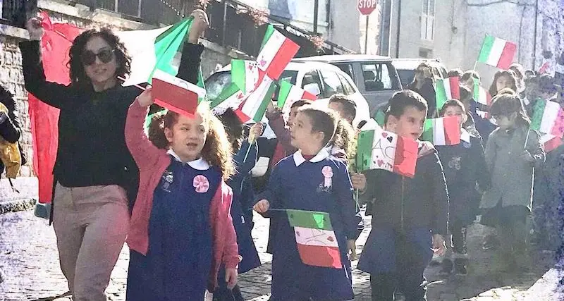Cerimonia del quattro novembre: i bambini depongono le bandierine tricolori accanto al monumento ai caduti e cantano l’Inno nazionale