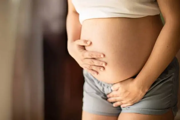 A pregnant constipated woman with bladder problems needing to pee, rushing to the bathroom.