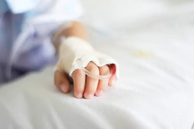 Saline intravenous (iv) drip in a Children\\'s patient hand