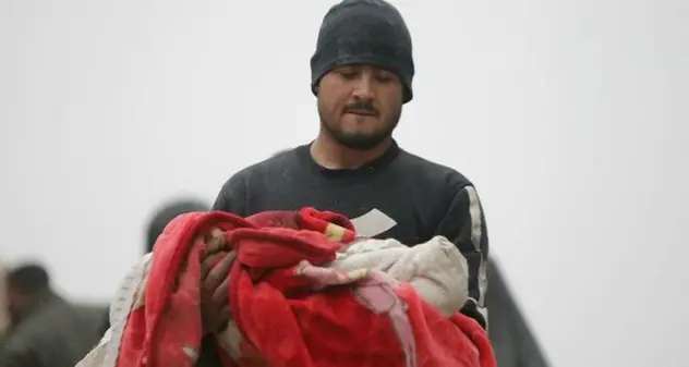 Terremoto: la disperazione di un papà che tiene in braccio il figlioletto morto