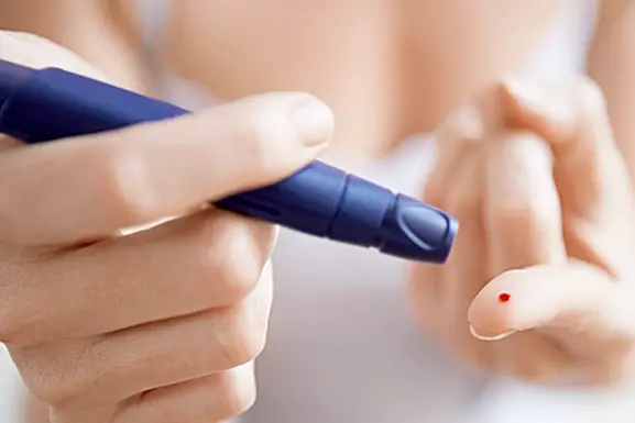 Woman Performing Blood Test on Herself