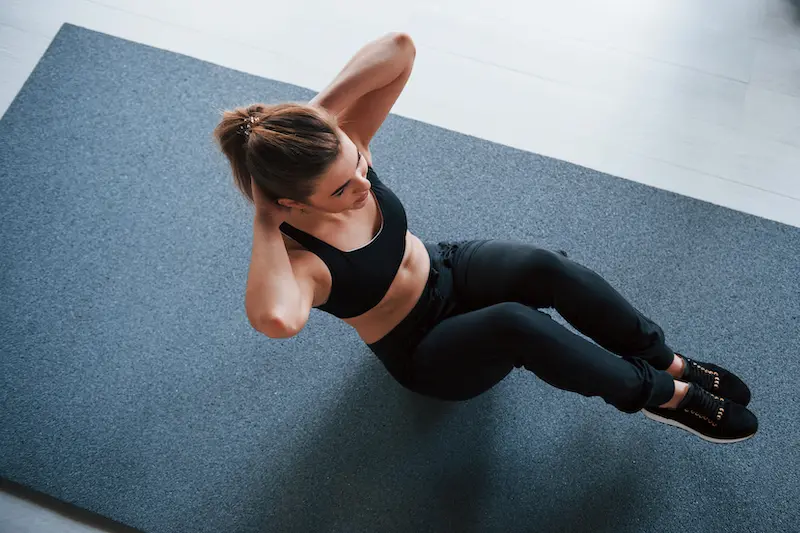 Nice blonde. Doing abs on the floor in the gym. Beautiful female fitness woman.