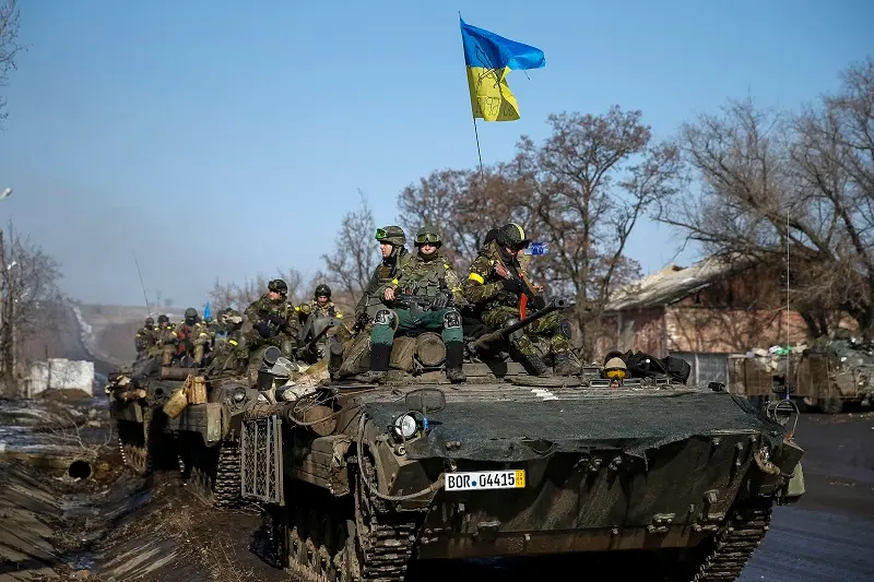 Members of the Ukrainian armed forces ride on armoured personnel carriers (APC) near Debaltseve, eastern Ukraine, February 12, 2015. Germany, France, Russia and Ukraine agreed a deal on Thursday that offers a \"glimmer of hope\" for an end to fighting in eastern Ukraine after marathon overnight talks.  REUTERS/Gleb Garanich  (UKRAINE - Tags: POLITICS CIVIL UNREST CONFLICT MILITARY) - RTR4PC4I