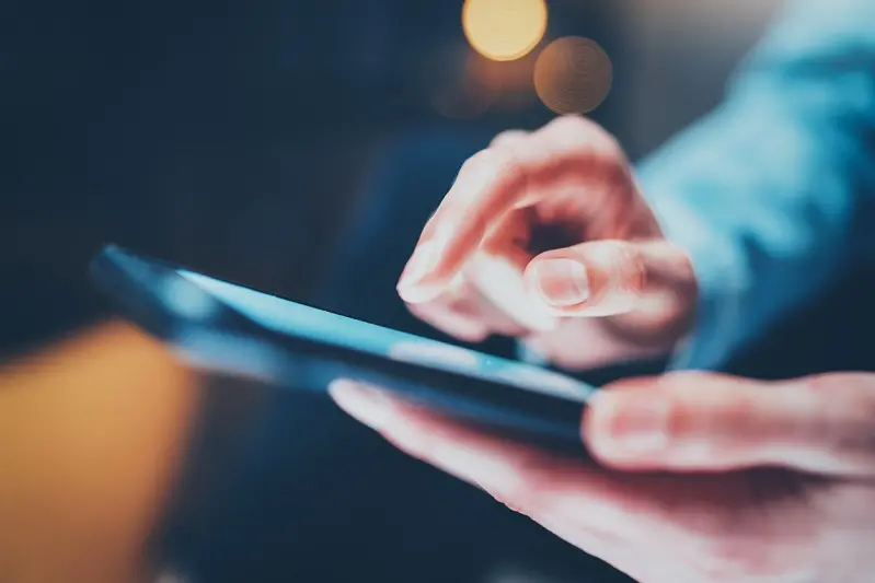 Closeup view of female hands touching smartphone white blank screen.Horizontal, blurred background, bokeh effects