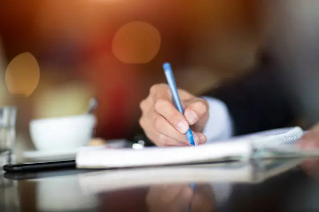 Businessman Writing At Cafe